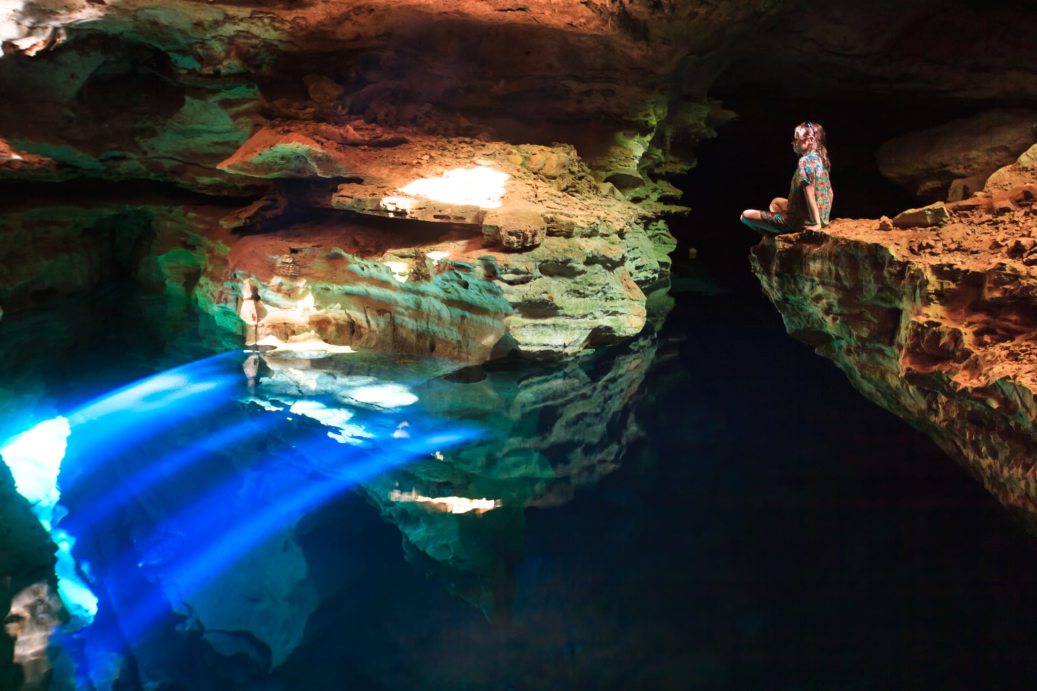 Feixe de luz iluminando as águas azuis do Poço Azul